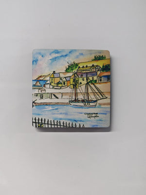 A square wooden magnet on a white metal background featuring the Charlestown watercolour print by R Singleton - reproduced with printing by HLSdesigner in Cornwall. Featuring the tall ship that frequents in the bay of Charlestown , views from the railings the opposite side of the bay - with the fishing village seen in the back ground, painted using colour washes and negative space. 
