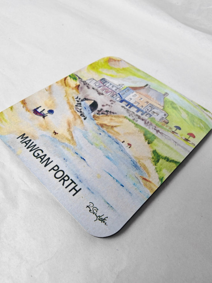 A square wooden coaster with rounded corners featuring Mawgan Porth beach near Newquay in Cornwall painted in watercolour by R Singleton focusing on the Merrymoor inn pub and the bridge where the stream flows under towards the ocean with beach goers on the sand. Printed exclusively at HLSdesigner