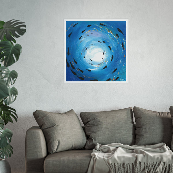 Blue abstract artwork depicting a fish shoal swimming under the ocean surface displayed on a wall above a grey sofa with a plant to the left. hlsdesigner.