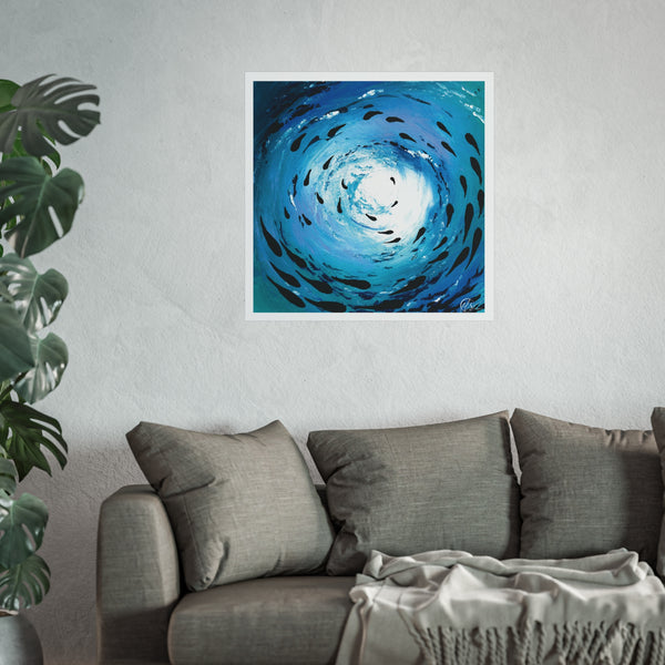 Blue abstract artwork  of fish swimming under the sea in a shoal formation with the light reflecting above the ocean surface displayed on a wall above a gray sofa with a plant to the left.