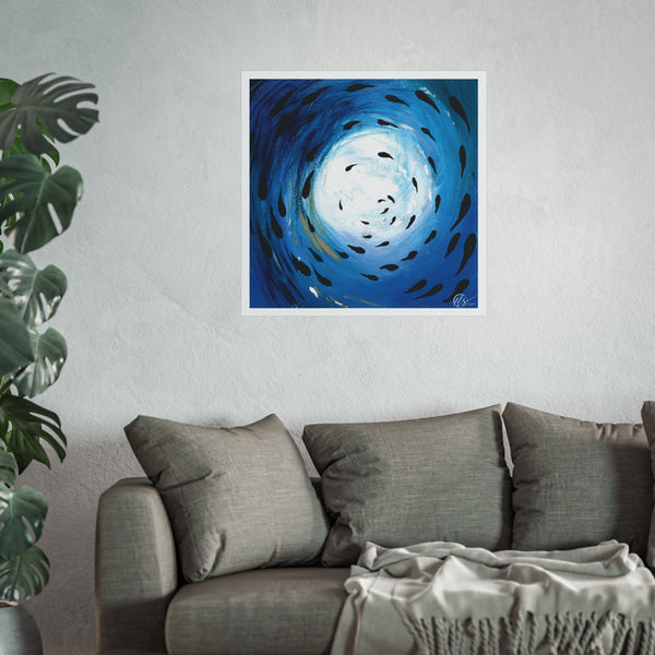 Blue abstract spiral art print depicting a fish shoal swimming through the ocean displayed on a wall above a grey sofa with a plant to the left. Hlsdesigner
