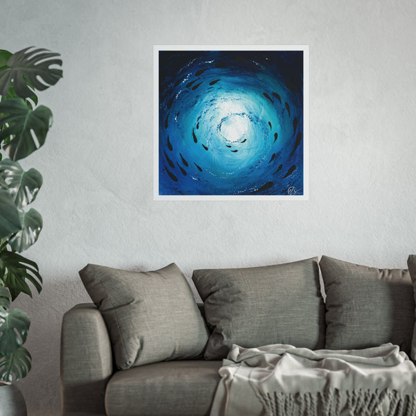 Blue abstract artwork depicting a fish shoal swimming under the ocean displayed on a wall above a grey sofa with a plant to the left. HLSdesigner