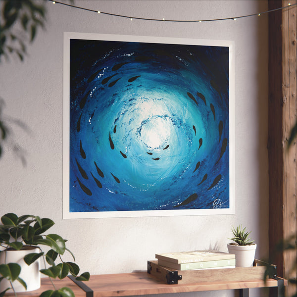 Framed abstract artwork with blue hues fading into black with black fish shapes as a shoal of fish swims under the ocean surface, painting by hlsdesigner displayed on a wall above a wooden shelf.