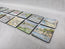 A set of illustrated magnets, watercolour print of R Singleton coastal cornwall paintings of various townscapes and beaches around cornwall. Collectable magnets lay together on a white background. Featuring perranporth, Charlestown, Porth beach, Polperro, Newquay, padstow and more. Designed and painted by R Singleton and reproduced into magnets by HLSdesigner in Cornwall, printed on wooden magnets with a high gloss finish