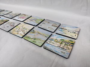 A set of illustrated magnets, watercolour print of R Singleton coastal cornwall paintings of various townscapes and beaches around cornwall. Collectable magnets lay together on a white background. Featuring perranporth, Charlestown, Porth beach, Polperro, Newquay, padstow and more. Designed and painted by R Singleton and reproduced into magnets by HLSdesigner in Cornwall, printed on wooden magnets with a high gloss finish