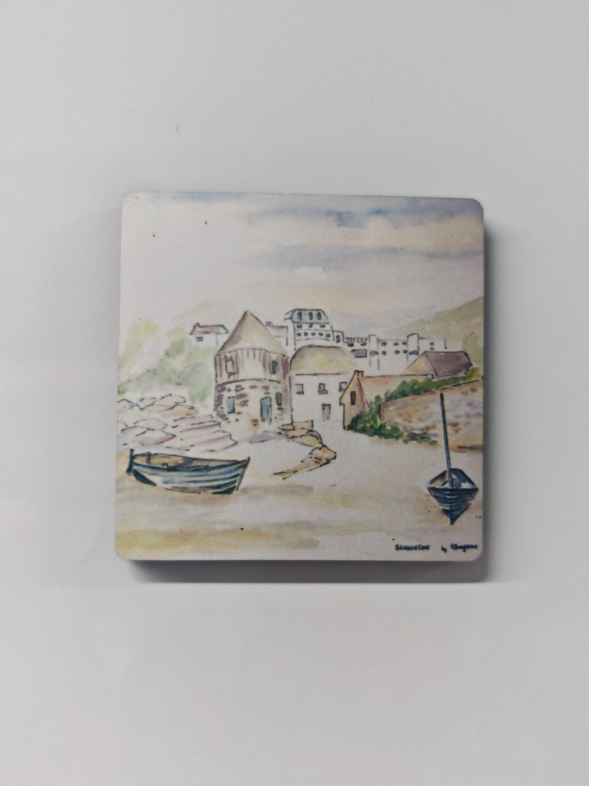 A square wooden magnet with a high gloss finish featuring a print of a painted watercolour scene of a Cornish coastal village with boats, displayed against a plain light grey background. This is Sennen Cove in Cornwall - painted in watercolour by R Singleton and reproduced exclusively by HLSdesigner