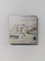 A square wooden magnet with a high gloss finish featuring a print of a painted watercolour scene of a Cornish coastal village with boats, displayed against a plain light grey background. This is Sennen Cove in Cornwall - painted in watercolour by R Singleton and reproduced exclusively by HLSdesigner