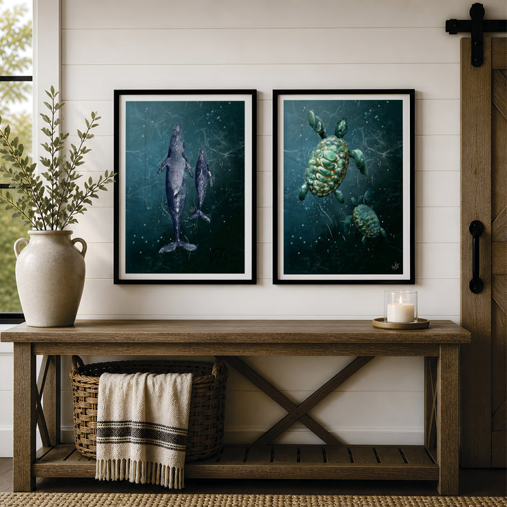 Two framed marine art prints hanging on a white shiplap wall above a rustic wooden bench. The left print shows a dark blue-grey whale print, and the right print shows green sea turtles in a deep teal underwater scene. Designed and created by HLSdesigner 