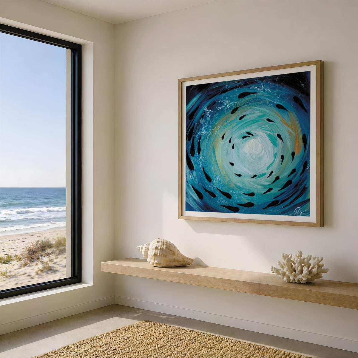 A framed square wall art print depicting a swirling blue and turquoise ocean scene with black fish, displayed in a modern room with a window overlooking the beach and ocean. Fish shoal 3 - depicting an abstract and expressionist form of an ocean vortex with fish swimming throughout the motion of the sea, with gold hues and bright light reflecting through the painting to show sunlight reflecting through the surface. A coastal inspired underwater themed art print designed by Hannah Singleton at HLSdesigner