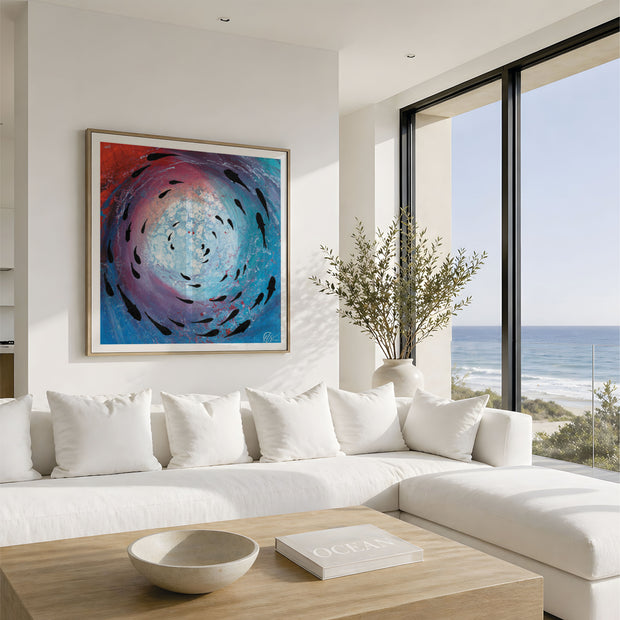 A framed abstract painting featuring a swirling vortex of blue, purple, and red with black fish-like shapes, displayed on a white wall above a modern white sectional sofa in a bright coastal living room.This is fish shoal 8 - a abstract collection of 12 pints featuring shoaling fish s you look up toward the surface. Designed by Hannah Singleton at HLSdesigner, coastal inspired art inspired by the ocean viewpoints.
