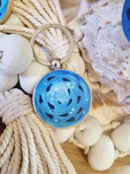 Blue decorative fish shoal pattern, hand painted with inspiration from the HLSdesigner shoal series of fine art prints and paintings - on a keychain on a background of seashells and rope