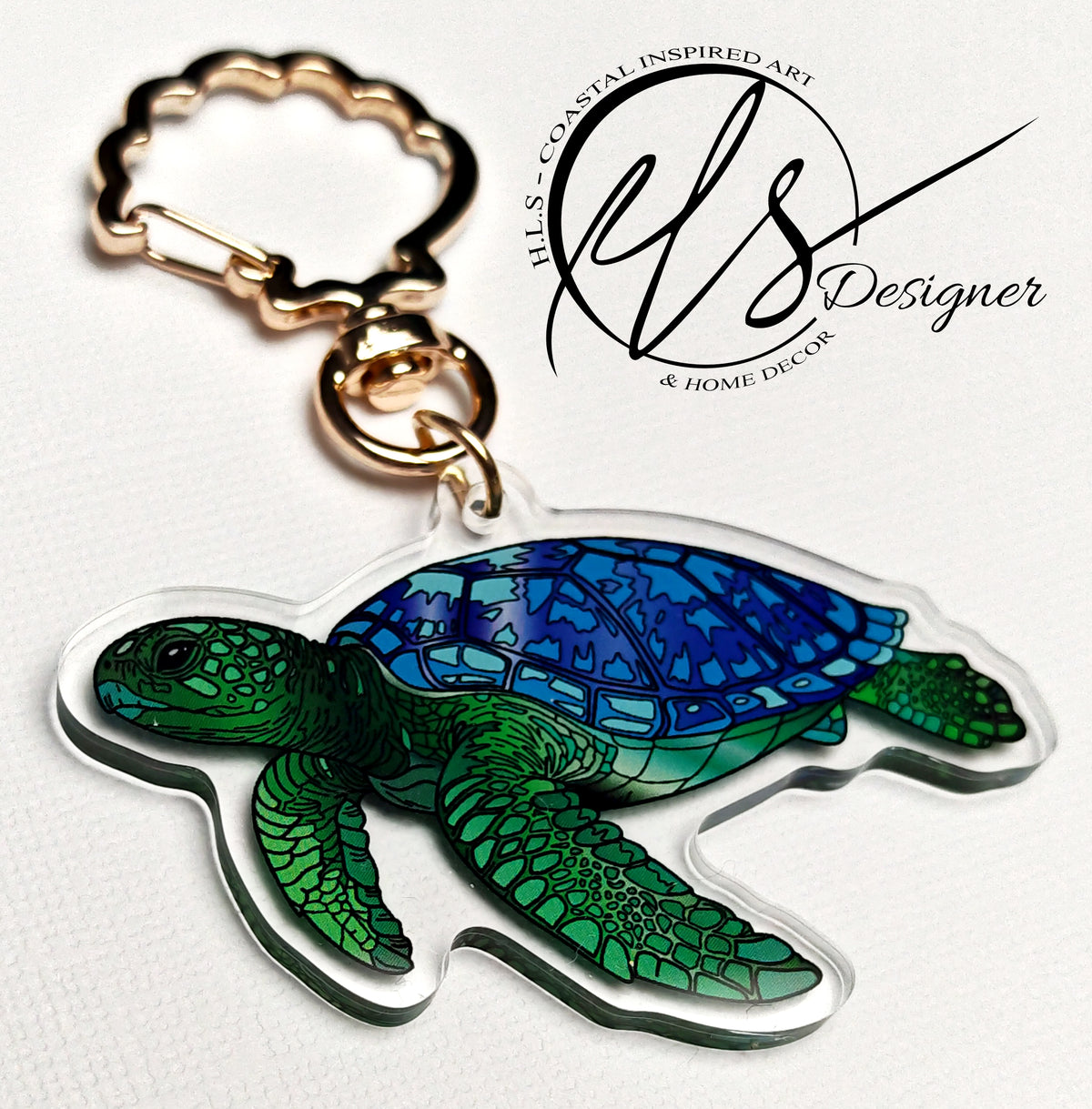 Turtle-shaped keychain with mosaic design on a white background, featuring HLSdesigner Coastal Inspired Art logo. Keychain is made from acrylic with a seashell clasp in gold. 