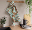Colorful towel with nature-themed lobster design with a nautical striped background, hanging on a wooden rack in a kitchen setting.