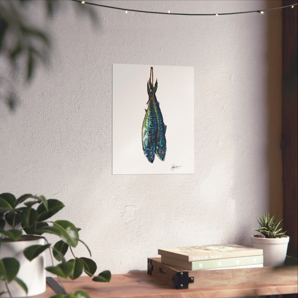 Framed artwork of a colorful fish on a wall above a wooden table with plants.