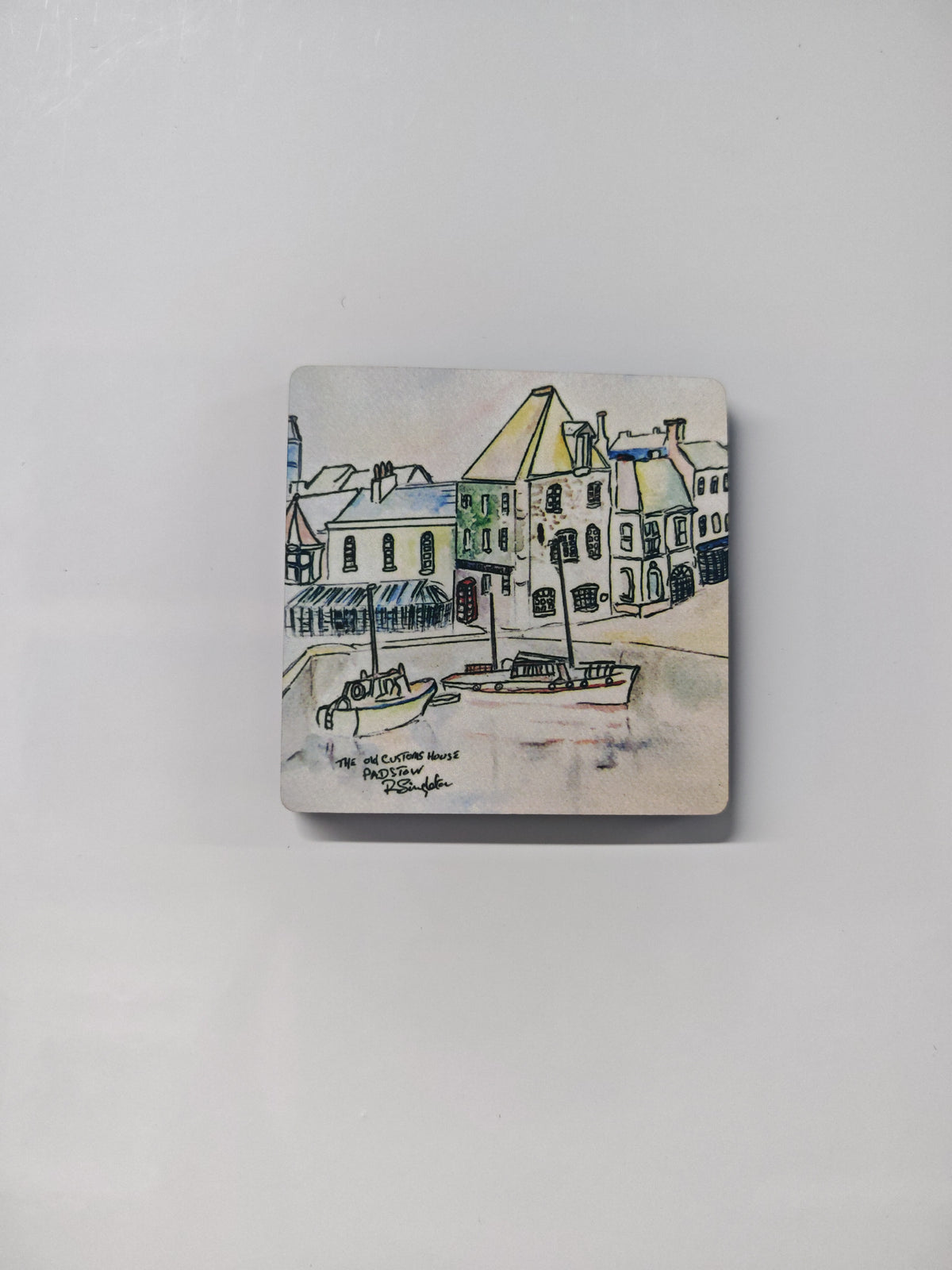 The old customs house in Padstow, Cornwall - a watercolour study by R Singleton and reproduced as tribute exclusively by HLSdesigner. featuring fishing boats moored in the harbour entrance with the customs house beautifully detailed with washes of colour and linear expressive work. A fridge magnet that can be collected as a memento of Cornwall 