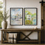 Two framed watercolour landscape prints of the old customs house in Padstow and the old watch house in Polperro - located in Cornwall - serene paintings of beautiful coastal villages in Cornwall. Hang on a white shiplap wall above a rustic wooden bench. The left print shows a coastal village with boats, and the right print shows a lakeside cottage. Originally painted by Robert Singleton - contemporary and minimalist artist from Newquay - Reproduced exclusively in honour by HLSdesigner