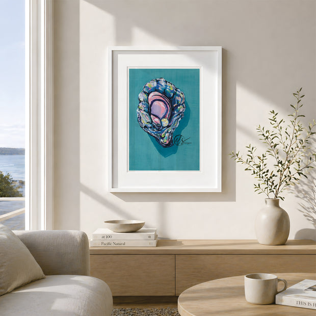 A framed art print featuring a colorful abalone shell illustration on a teal background, displayed on a beige wall in a modern, sunlit living room setting. This is a gouache painting to represent a colourful and vibrant king oyster featuring Lemon yellow hues paired lovingly with oyster blue and lilac shading to create a 3d effect. Painted and reproduced into prints by artist Hannah Singleton, ocean inspired illustrator and seafood artist from cornwall at HLSdesigner
