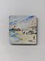a square magnet with rounded edges with a gloss coating  finish, featuring a print of the watercolour perranporth painting by R Singleton, coastal cornish scenes ready to collect, a pretty depiction with a lifeguard vehicle on the sand, paragliding and beach goers showcasing the cornish flag on the perran rock as the tide comes in.