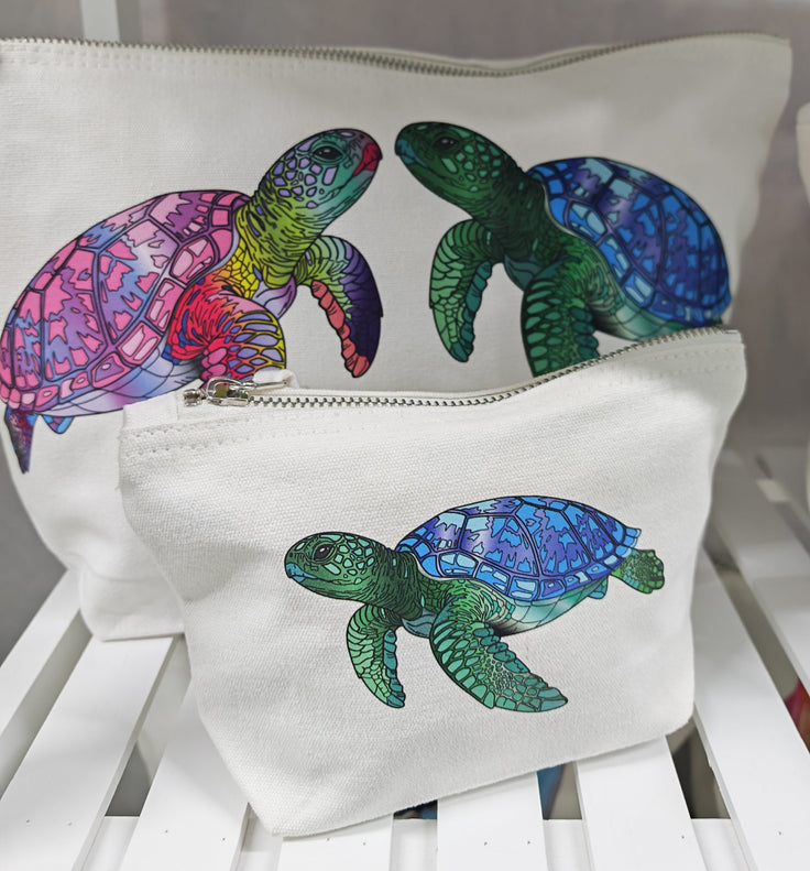 showing the large and the small accessory bag sizes, these showcase the pink and green turtles facing each other and the small bag has a single green turtle illustration pressed onto it 