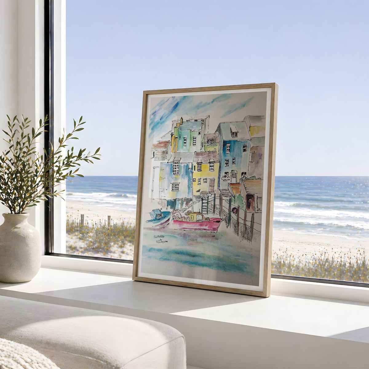A framed watercolor art print depicting a coastal village of Polperro in Cornwall. Featuring washes of water and beautiful boats moored with colourful houses that make this painting unique and beautiful, leaning on a white windowsill with a beach and ocean view behind it. Originally painted in watercolour by Robert Singleton , his work gives a contemporary and minimalist look suited for any home. Inspired by the coastal towns of Cornwall. Reproduced into fine art prints by HLSdesigner