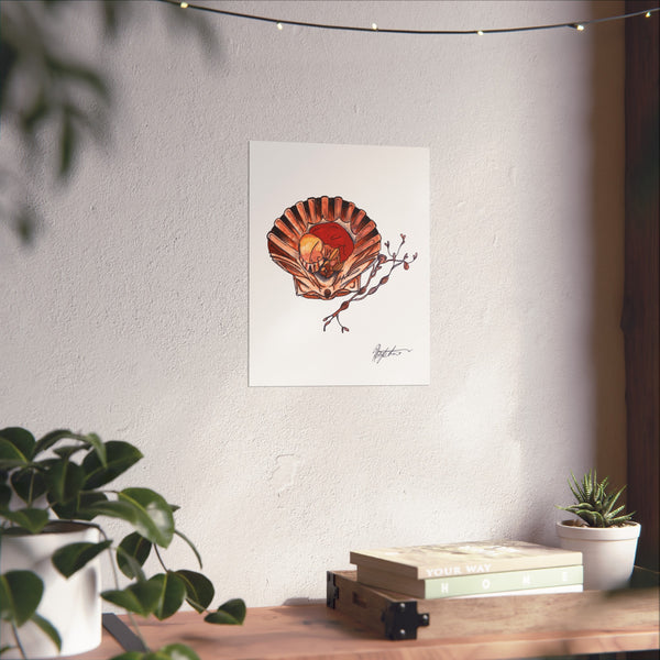 Framed artwork of a shell with a red center on a white wall above a wooden table with plants.
