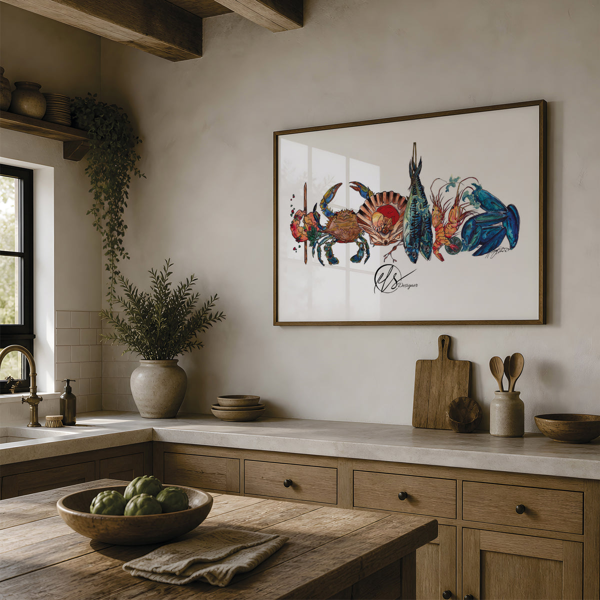 A framed art print featuring a colorful illustration of crabs and a fish on a white background, hanging on a beige wall in a rustic kitchen with wooden cabinets, a stone countertop, and a wooden island. The art on the wall is a piece by Hannah Singleton, a contemporary fine artist inspired by the ocean from Cornwall. This is the seafood platter print, featuring a prawn skewer, blue sand crab, scallop shell, mackerel, langoustines and mussels all layered together in a row ready for prep. at HLSdesigner