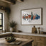 A framed art print featuring a colorful illustration of crabs and a fish on a white background, hanging on a beige wall in a rustic kitchen with wooden cabinets, a stone countertop, and a wooden island. The art on the wall is a piece by Hannah Singleton, a contemporary fine artist inspired by the ocean from Cornwall. This is the seafood platter print, featuring a prawn skewer, blue sand crab, scallop shell, mackerel, langoustines and mussels all layered together in a row ready for prep. at HLSdesigner