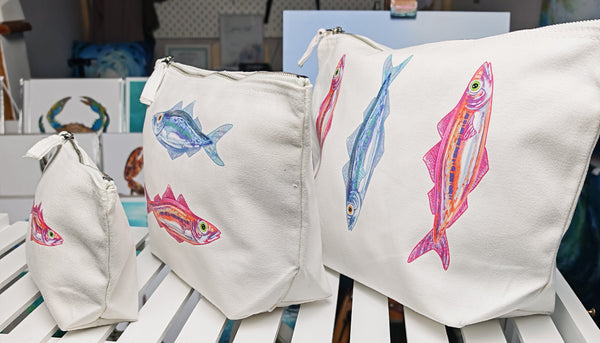 small, medium and large sardine cosmetic bags printed onto an off white brushed cotton canvas bag with silver zip, this features a pink and orange sardine illustration by hlsdesigner and is pressed in house. This is taken from a side view for size and capacity comparison
