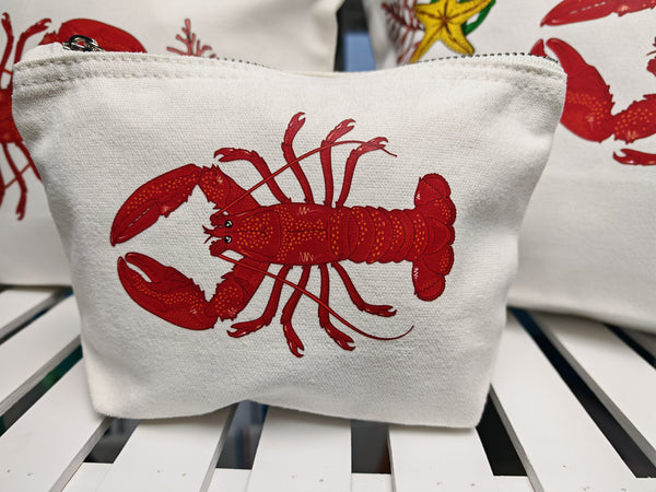 red lobster illustration by hlsdesigner printed and pressed in house onto beautiful cosmetic accessory bags, this one features the small bag close up on a white shelf and is complete with a silver metal zip.