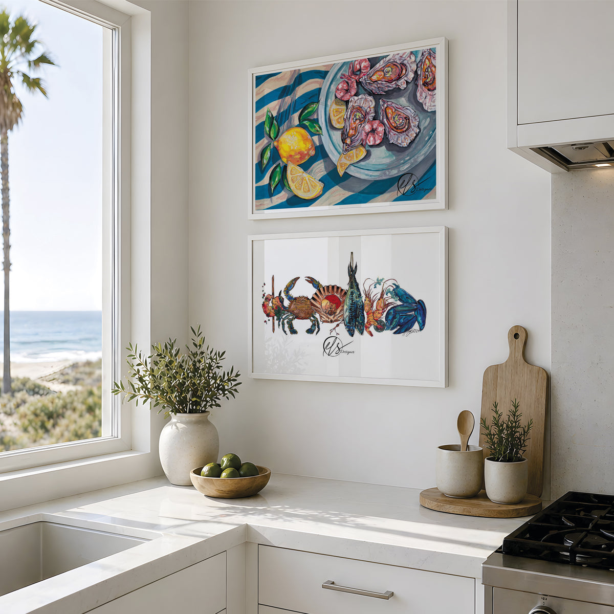 Two framed colorful paintings hanging on a white kitchen wall above a counter. The top painting shows a seafood platter of oysters with lemons and leaves on blue striped linens, and the bottom painting shows another seafood platter featuring various fish and shellfish, together making a cohesive set of art prints. Displayed in line with another on a white wall in a clean white kitchen, images are for reference only and do not display the prints to size scale. Designed painted and created by HLSdesigner
