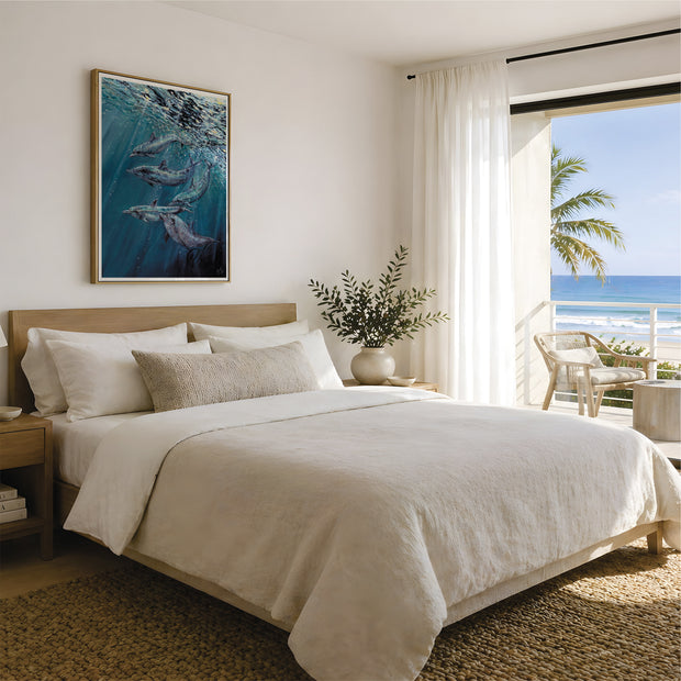 Underwater song, a depiction of dophins swimming under the ocean surface as the suns reflections pierce through and shine upon them, with deep indigo and turquoise blues featuring light fractals throughout the bubbles in the sea. A beautiful and tranquil sentiment to any home. Here it is displayed in a coastal beach house above a cream coloured bed with a private balcony adjacent. Images are for representation only and do not show the approximate sizing of the print. Watermarked by HLSdesigner
