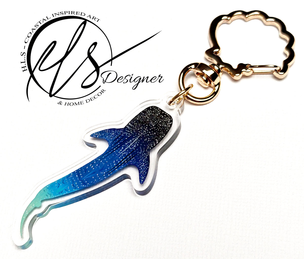 Blue shark-shaped keychain with gold ring on a white background, featuring Hills Coastal Inspired Art logo. constellation inspired whale shark illustration with spots, linear work and stars