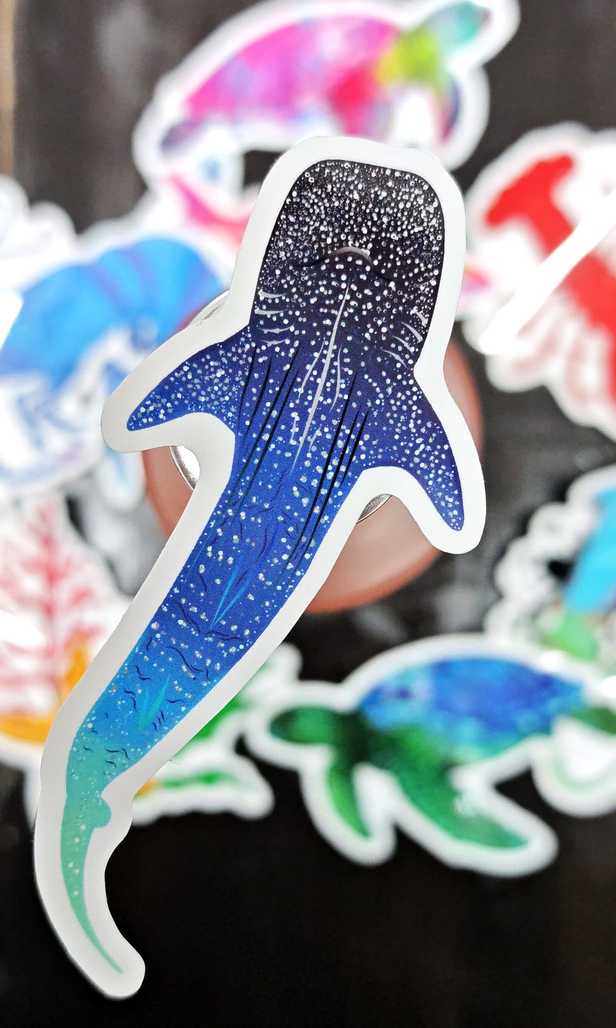 whale shark illustrated die cut sticker raised above a variation of other ocean creature stickers in the background by HLSdesigner