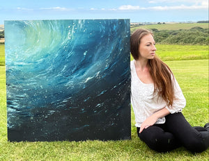Hannah Singleton sitting next to original ocean inspired painting from Cornwall HLSdesigner 